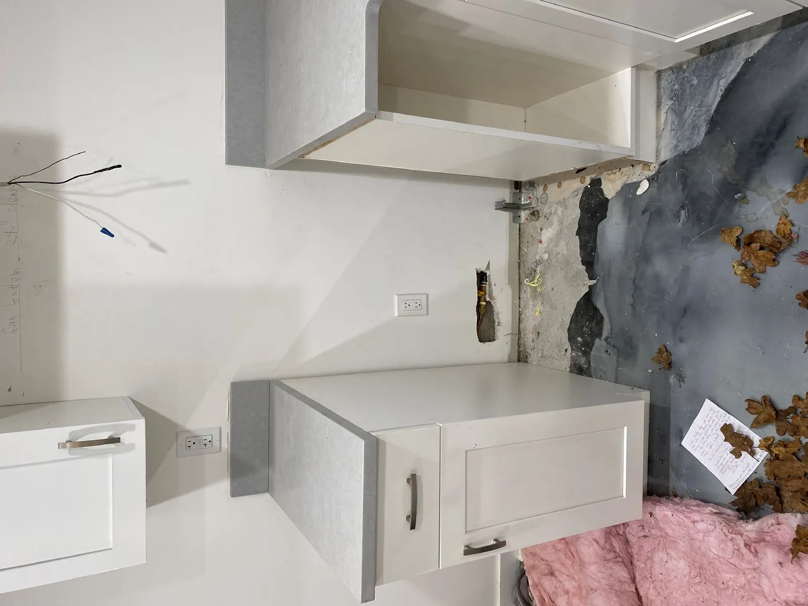 Bathroom wall with damaged drywall where a fixture was removed