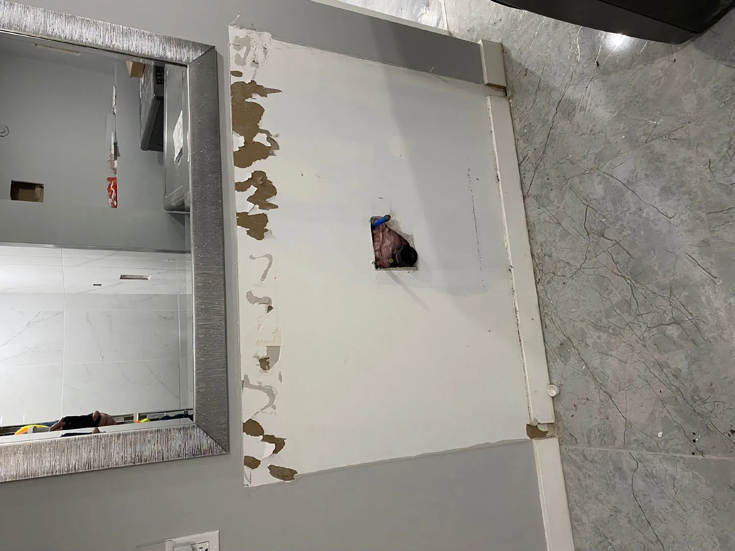 Tiled bathroom floor showing an uncapped plumbing drain