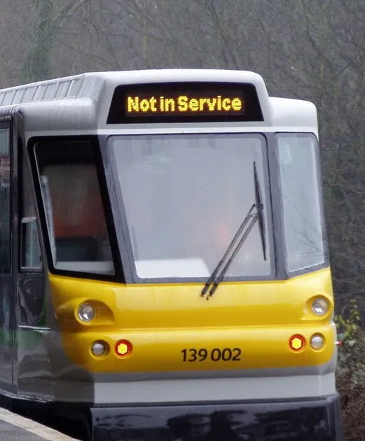 Front view of a yellow and grey light rail vehicle numbered 139 002 with a "Not in Service" destination sign