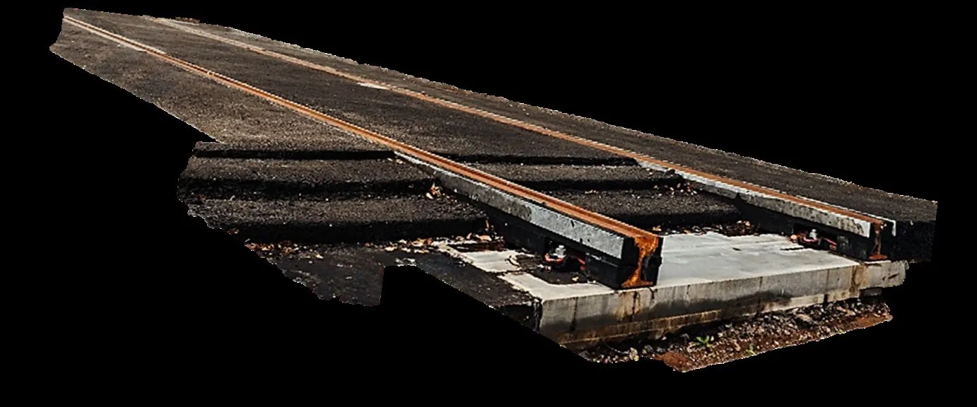 Photo of a cyclist on a trail passing a section of track rails embedded in the path