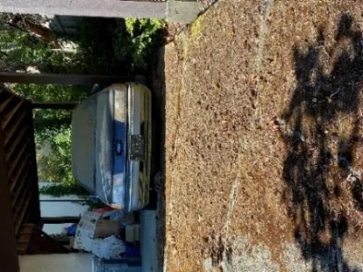 Side view of a derelict Ford Taurus covered in dust with flat tires