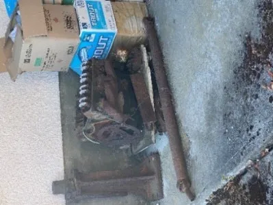 Front-angle view of the derelict car parked under a carport structure