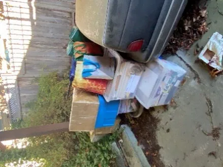 Pile of boxes and discarded household materials in a carport