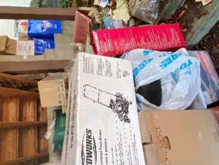 Stacked boxes including an Earthworks box alongside other rubbish