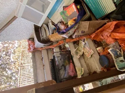 Close-up view of accumulated junk including papers and containers