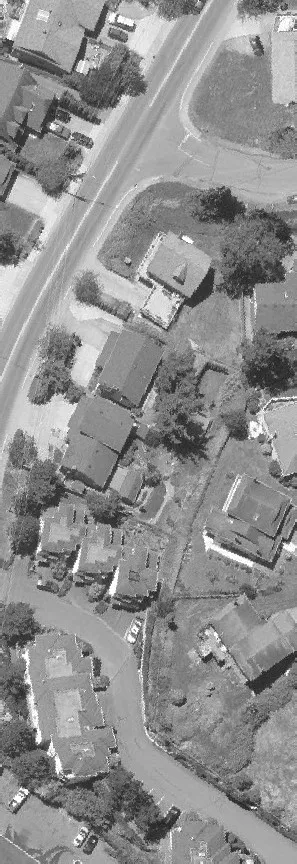 Aerial view of a large building roof and surrounding parking area