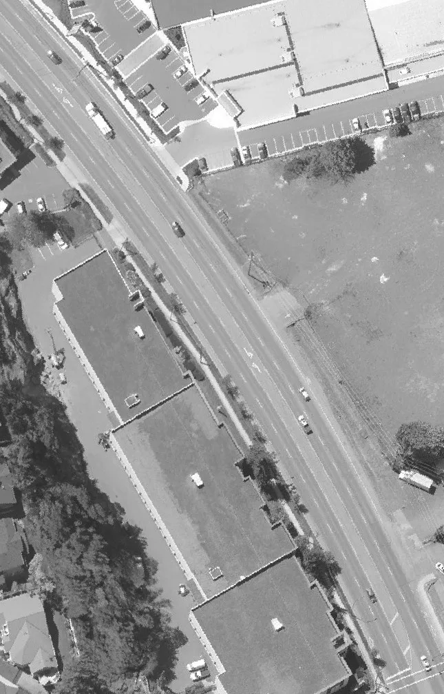 Aerial view of a large residential complex and parking near trees