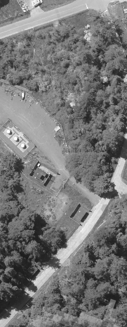 Aerial view of a road and parking lot with multiple vehicles