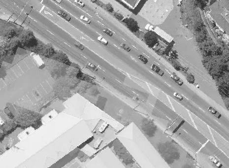 Aerial view of a multi-lane road with lane markings and nearby trees