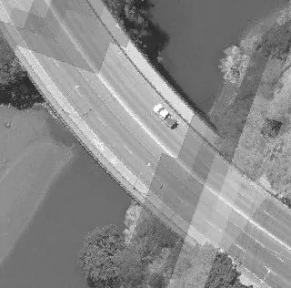 Aerial view of a roadway intersection with parking lots and commercial buildings