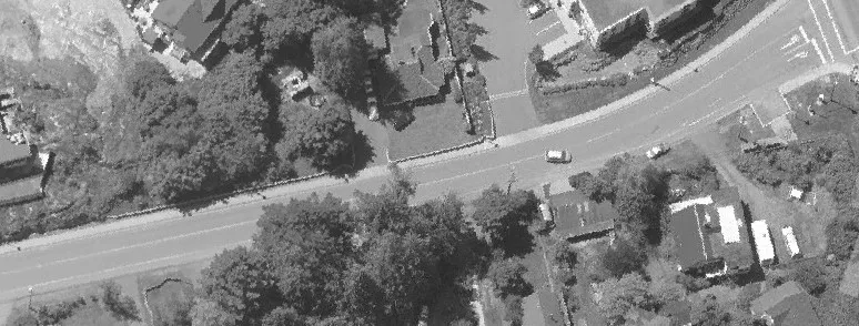 Aerial view of a residential street with houses and yards