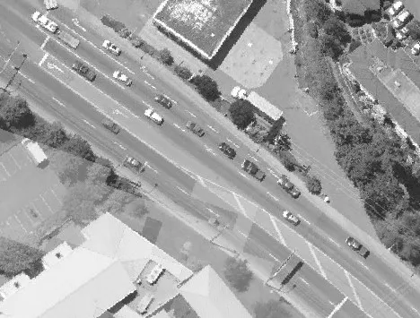 Aerial view of a paved road winding through a heavily treed area