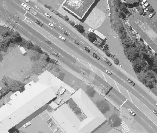 Aerial view of a roadway and parking lot with several vehicles