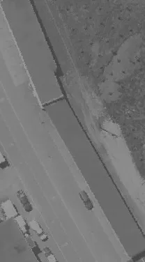 Aerial view of a narrow road passing through a wooded region