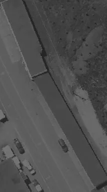 Aerial view of a coastal area with water meeting a treed shoreline