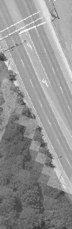 Aerial view of a multi-lane road bordered by a line of trees