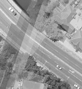 Aerial view of a multi-lane road bordered by a line of trees