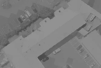 Aerial view of building rooftops and paved parking surfaces