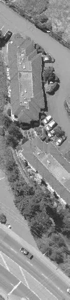 Aerial view of a long commercial building and nearby road