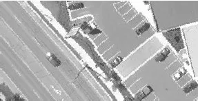 Aerial view of a road and parking lot with multiple vehicles