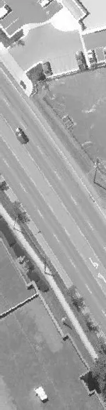Aerial view of a road cut through a dense forest