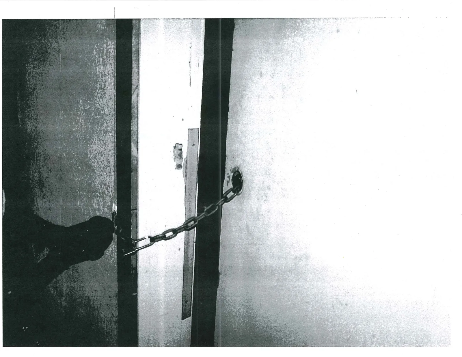Metal chain attached to a floor anchor at a door threshold