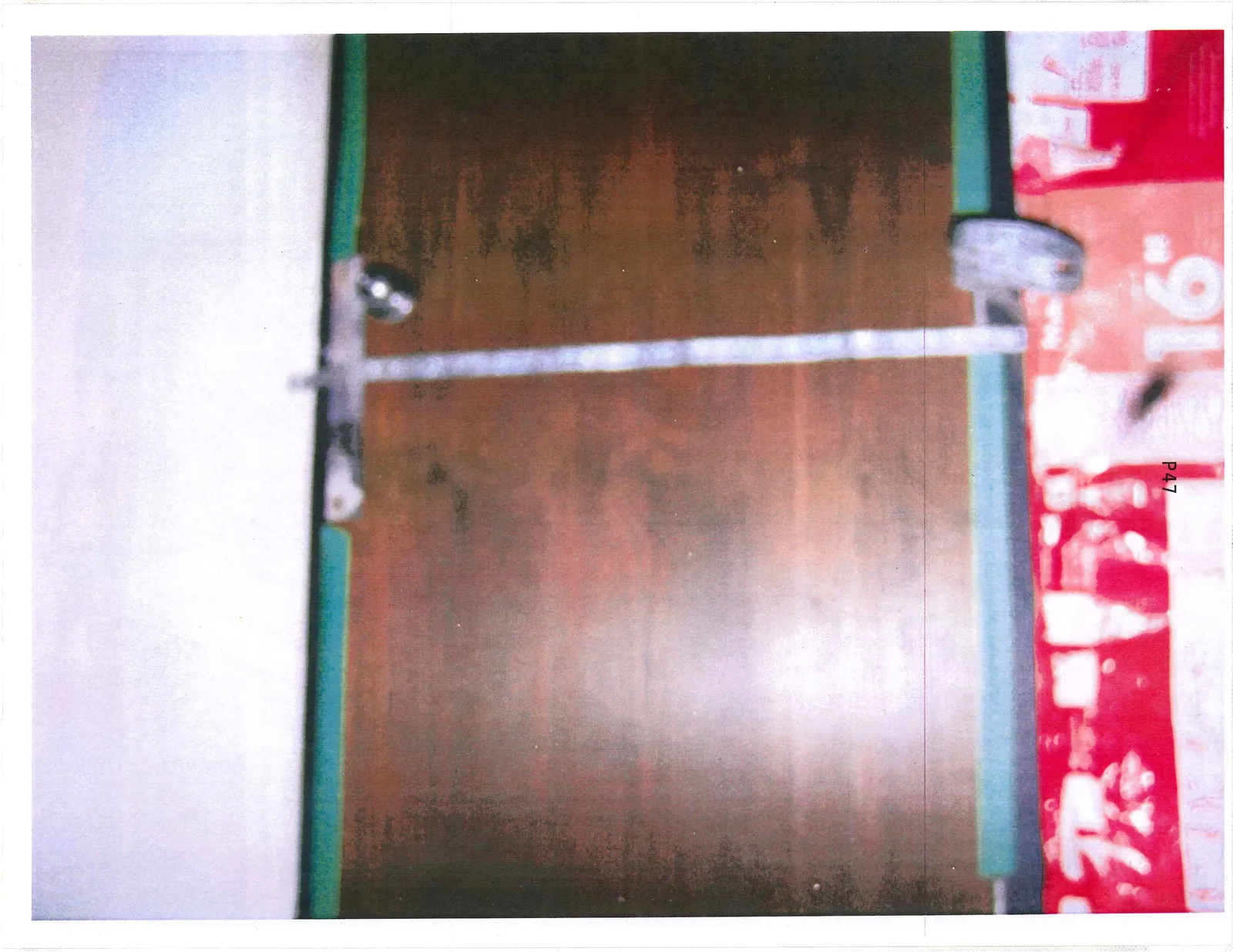 Wooden door with a makeshift horizontal metal bar for reinforcement