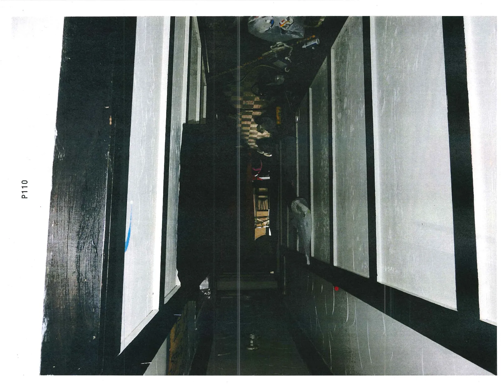 View of an interior hallway or room featuring white wall panels with dark wooden trim