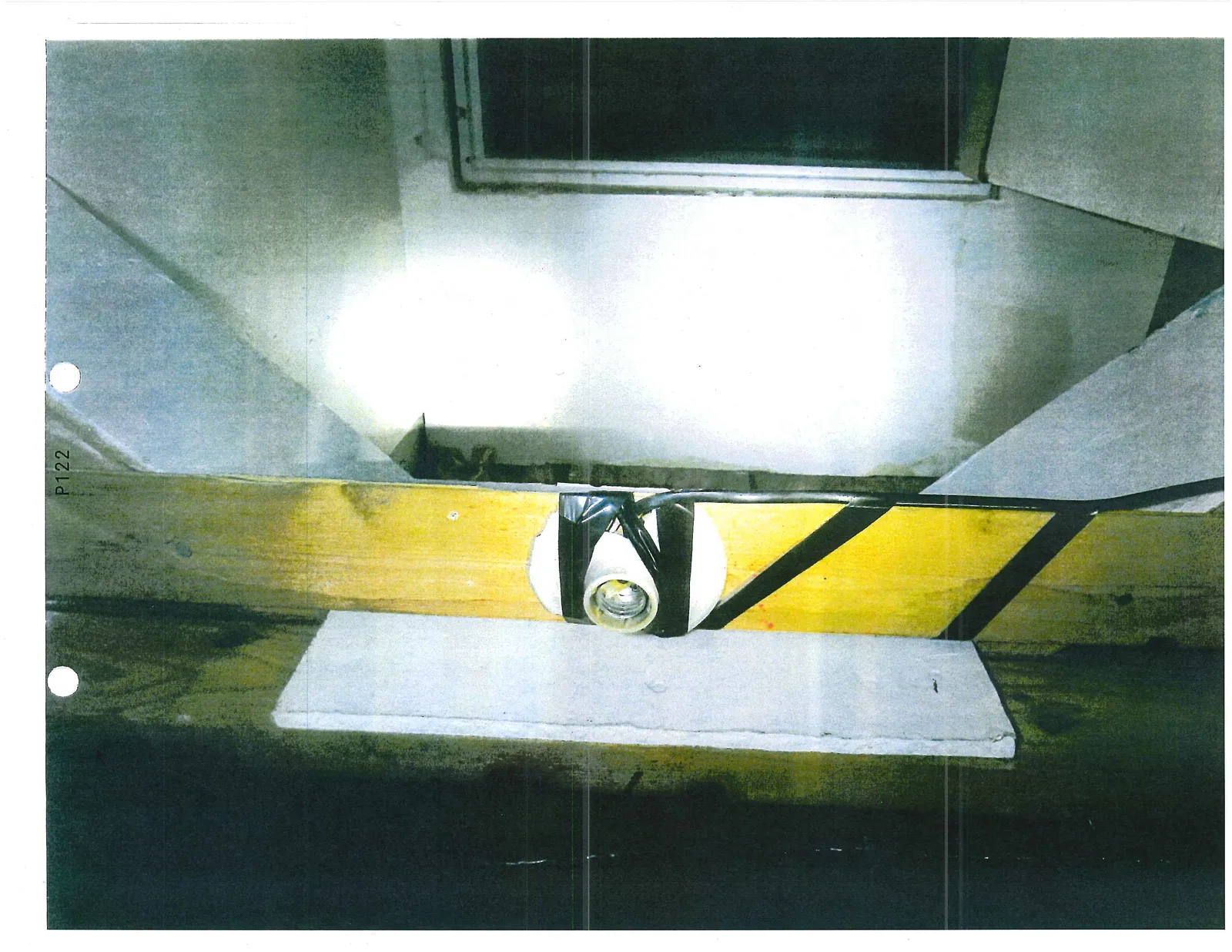 Porcelain light socket secured to a wooden stud with black electrical tape