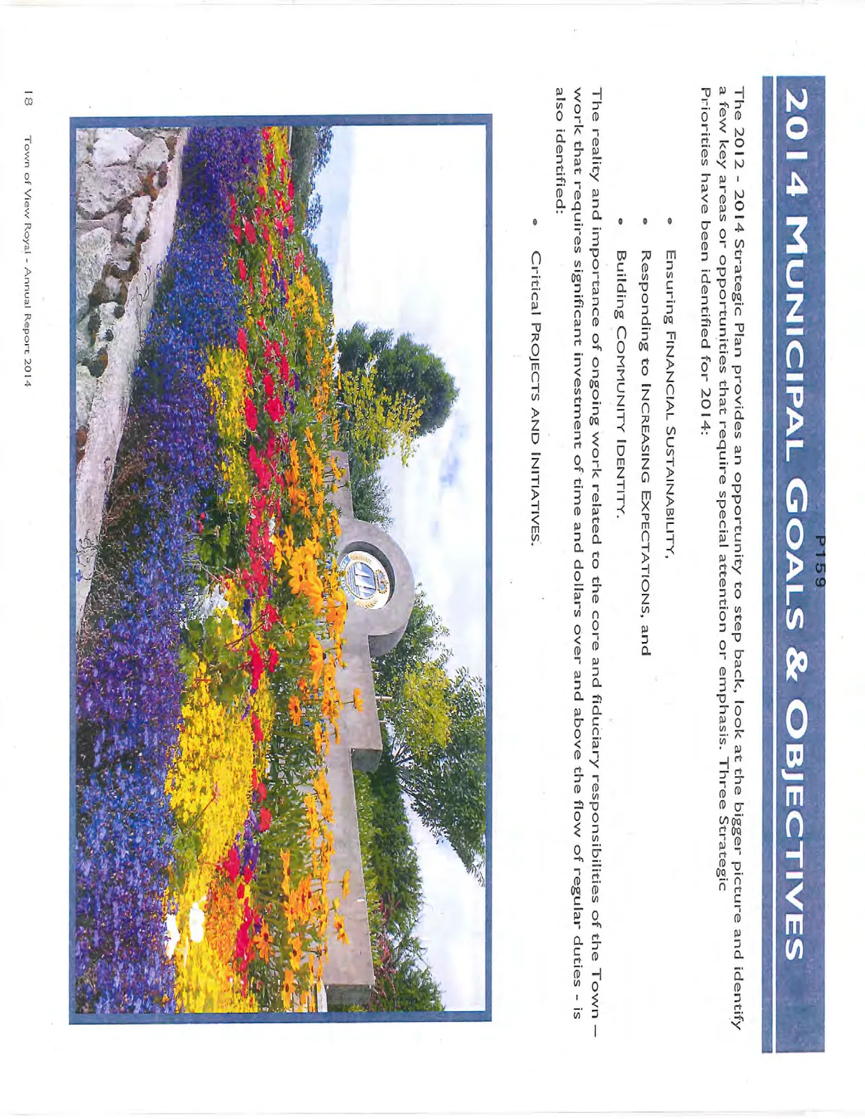 A colorful flower garden in front of a stone wall with a circular emblem.