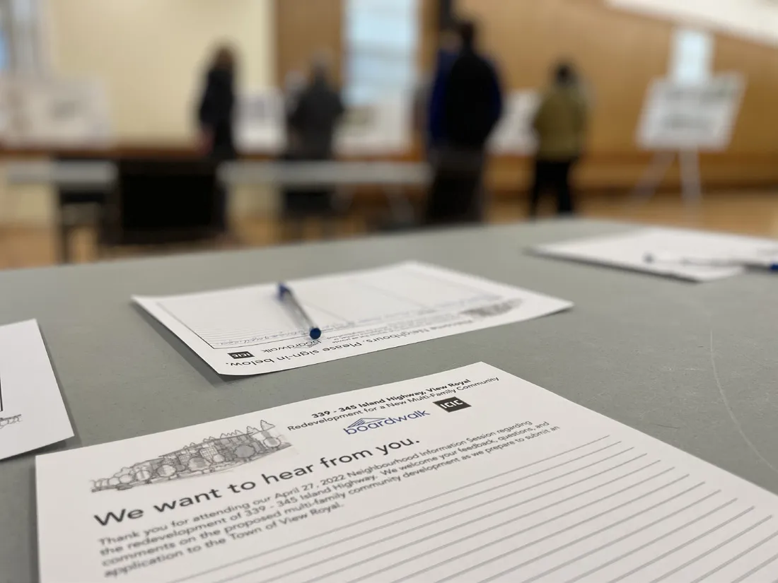 Photo of community members reviewing project display boards at the December 2022 neighbourhood information session.
