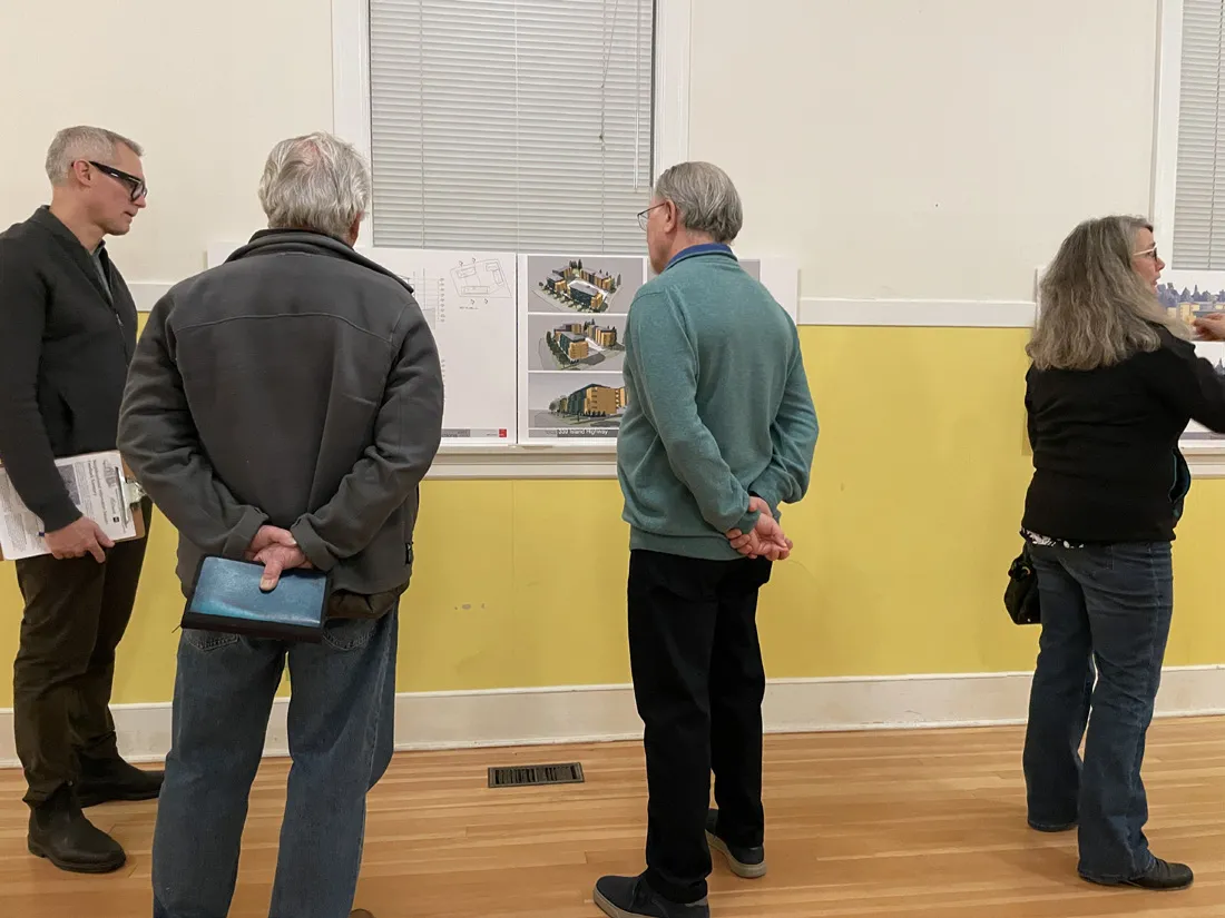 Photo of community members reviewing site analysis and design boards at the August 2023 neighbourhood information session.