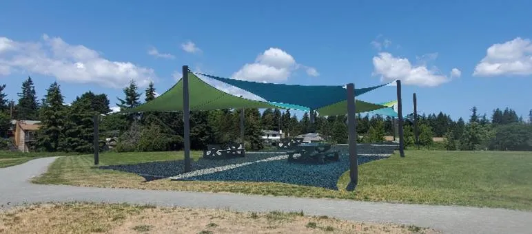 Design concept rendering of a shade structure with picnic tables in an open field