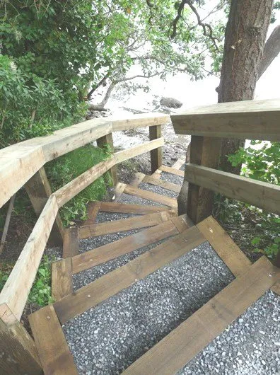 Wooden stairs leading down to a rocky shoreline