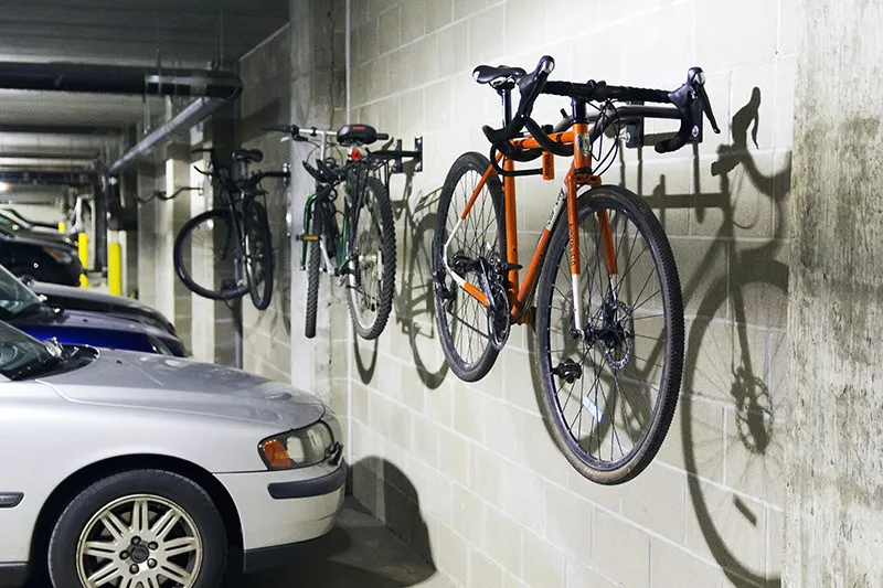 Bicycles mounted on blue wall racks in a parking garage