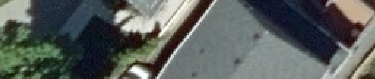 Aerial view crop of a house roof and driveway area