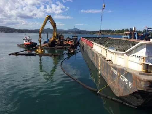 Tugboat maneuvering a dredging barge