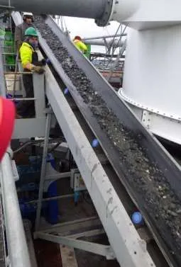 Conveyor belt transporting dredged and processed material