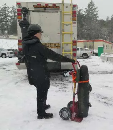 Personnel moving a recovered 250lb Training Round on a dolly