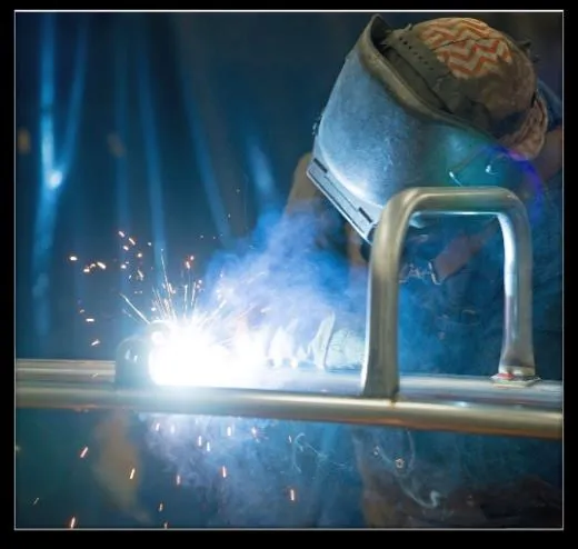 Photo of a worker welding playground components