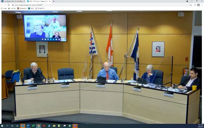 Council meeting in Chambers showing members at the table and virtual attendees on a screen