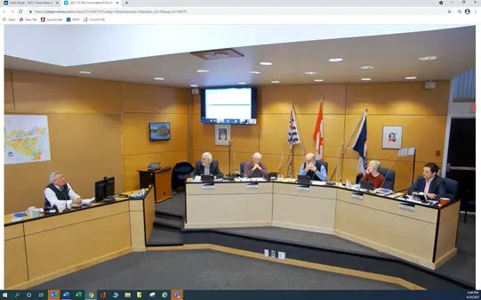 Wide shot of the council chamber during a meeting showing the members seated at the dais