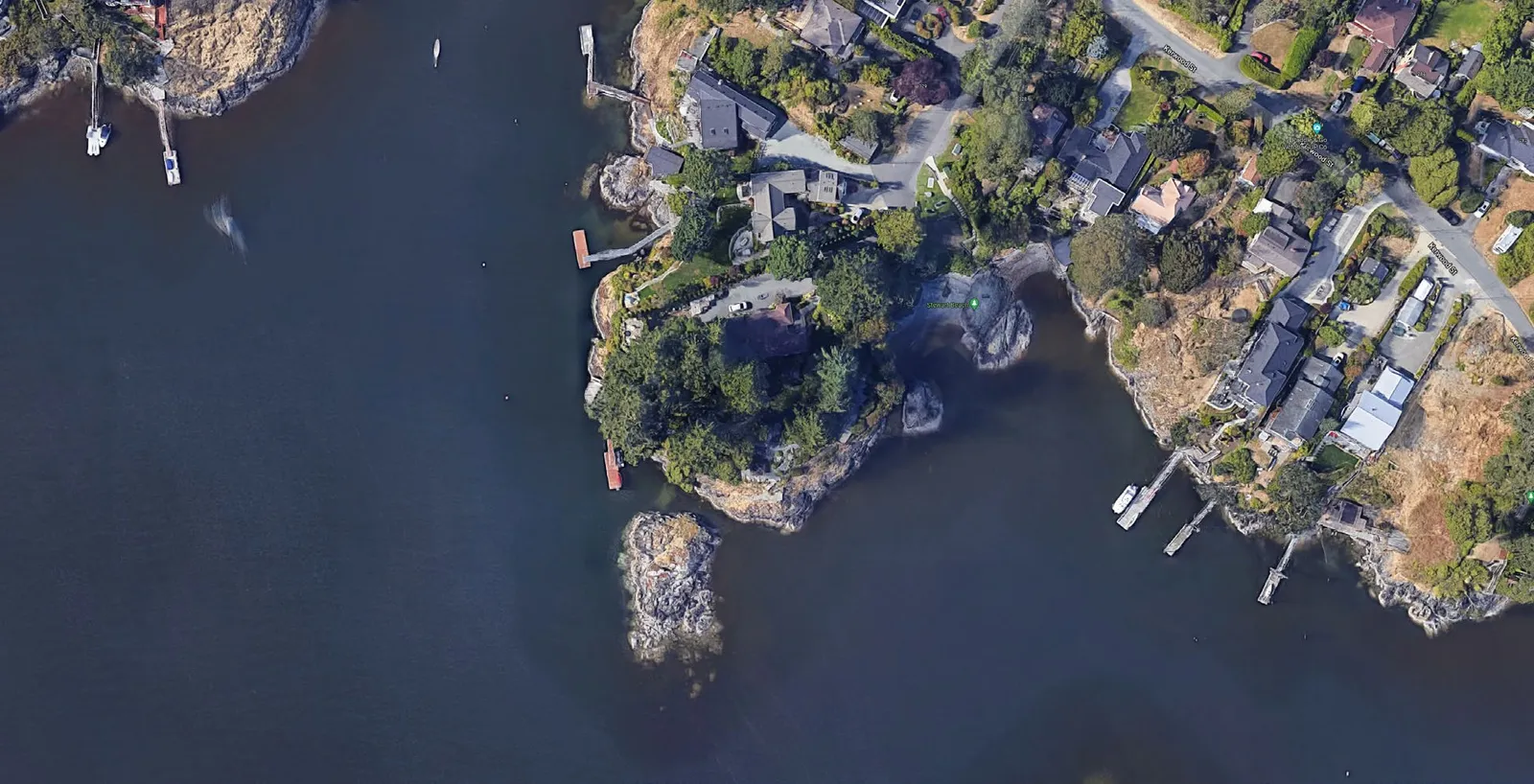 Aerial view of the subject property and surrounding shoreline with a red circle indicating the dock location