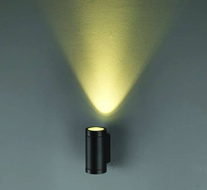 Cylindrical black wall-mounted LED light fixture providing downward illumination