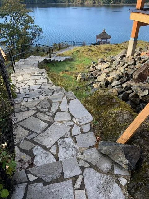 Stone steps descending toward a gazebo on the lake