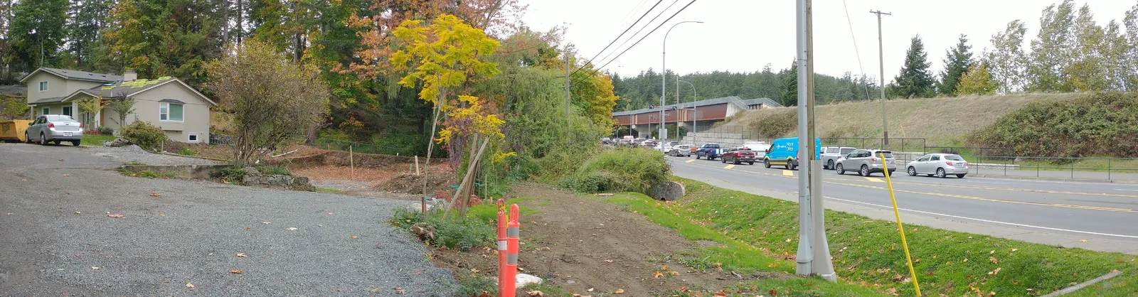Site photograph indicating the shared access, property line, and the proposed main floor elevation relative to Island Highway
