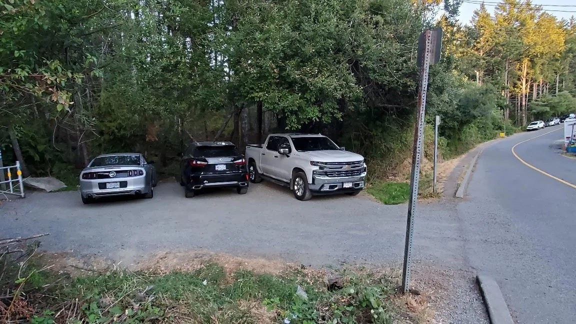 Photo showing three vehicles parked at the Phelps Trail parking area