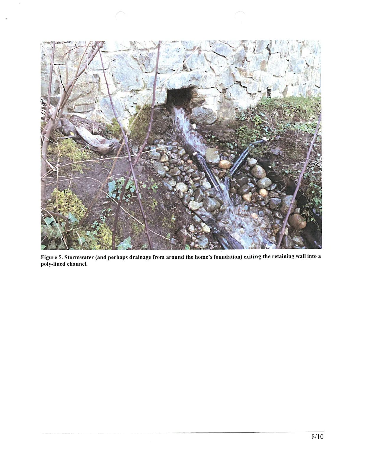 Figure 5. Stormwater (and perhaps drainage from around the home's foundation) exiting the retaining wall into a poly-lined channel.
