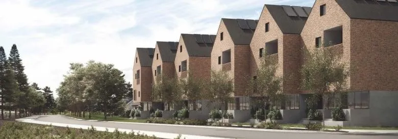 Architectural rendering of a row of modern, multi-story brick townhouses with solar panels on pitched roofs