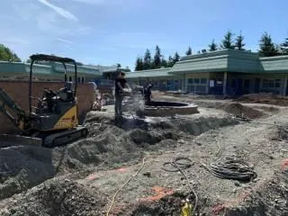 Excavator placing large rocks for the garden landscape